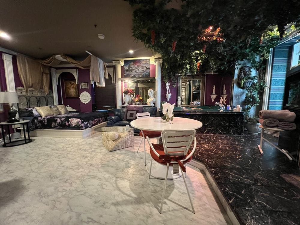 Photo of a themed suite with a vine canopy, columns, a canopy bed and a marble floor